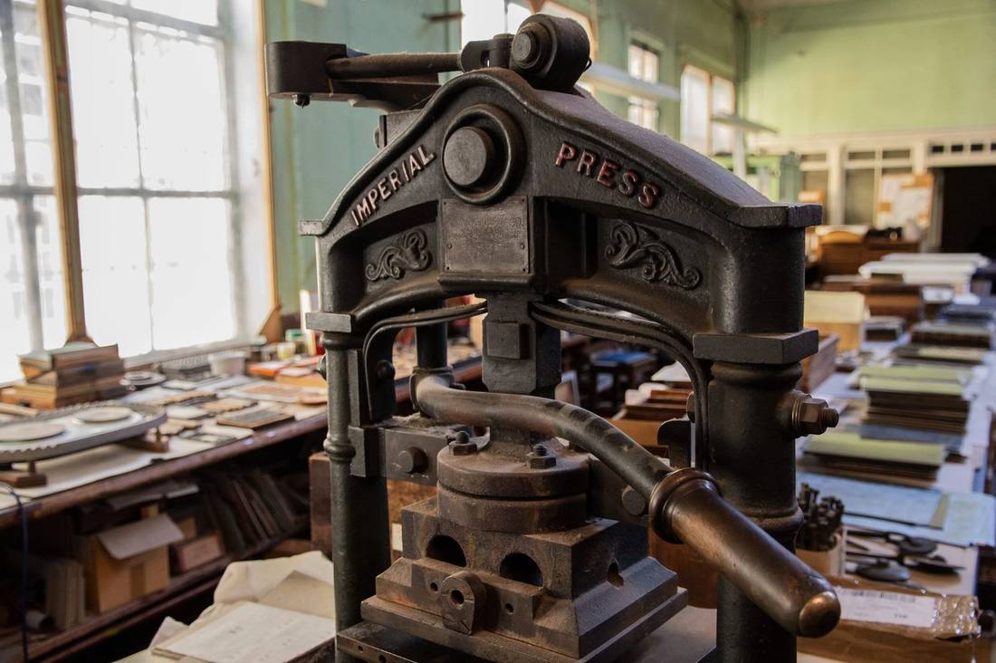The Bayntun-Riviere bindery on Manvers Street, with a long bench, the tool wall, and a binding in finishing.